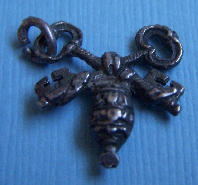 Vintage silver charm featuring intricate papal keys design-image