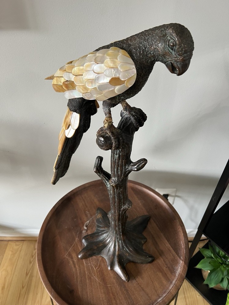 This is a bronze sculpture of a parrot with mother-of-pearl feathers.